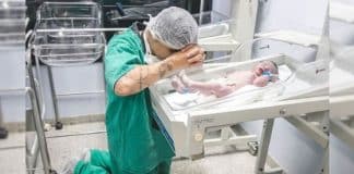 Foto de pai ajoelhado ao lado do berço do filho emociona redes sociais
